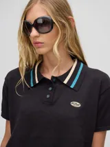 Chomba corta roja de algodón con cuello camisero con rayas celeste y negra. Logo bordado en el frente.