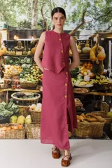 Top sin mangas color fucsia de lino, con cartera asimétrica y botones de madera. Tiene ojales bordados con forma de frutas.