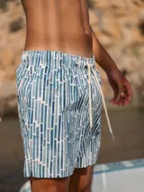 Short de baño azul con estampado de rectángulos blancos y celestes, con cintura elástica ajustable con cordón.