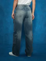 Pantalón de jean cargo de tiro alto, color azul medio desgastado, con corte ancho y bolsillos cargo a los lados de las piernas.