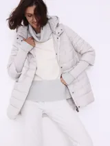 Campera matelassé color gris claro con capucha y puños tejidos, de corte corto.