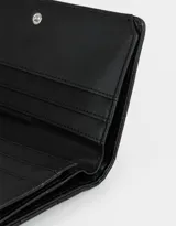 Billetera negra de cuerina acolchada con formato de fichero. Tiene solapa con broche a presión, compartimentos para tarjetas y billetes, y un tag en relieve con la frase "You're pretty great".