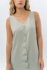 Vestido midi de lino en color verde seco, con escote en V, diseño sin mangas y cierre frontal con botones de madera. Presenta un corte recto y fluido con una abertura frontal en el bajo.
