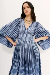 Vestido midi con escote en V, mangas amplias y recorte en la cintura, confeccionado en viscosa con estampado de rayas azules.