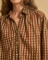 Camisa marrón con estampado de líneas verticales color crema, corte holgado y cuello clásico.