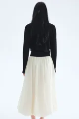 Saco negro de punto fino y suave de mezcla de viscosa con botones adelante. Cuello, puños y bajo en punto elástico acanalado.