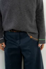 Sweater de punto gris con cuello en V y ribetes en contraste.