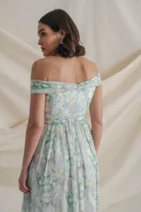 Vestido largo de gasa de seda natural estampada en tonos blanco, verde y amarillo. Diseño drapeado con escote barco y manga caída, falda con movimiento y tajo lateral.