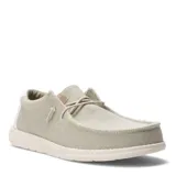 Zapatos tipo mocasín de tela color beige, con cordones elásticos y suela blanca.