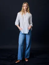 Blusa blanca de gasa bambula, marca Zac & Rachel. Cuello a la base, escote en V con apertura y botones. Largo de manga regulable con presilla y botón.