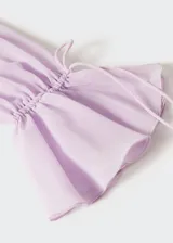 Vestido largo lila semitransparente con cuello en V, volantes en el escote y mangas largas con volantes.