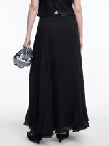 Falda larga negra con textura arrugada y volado en el ruedo. Confeccionada en lyocell y poliamida.