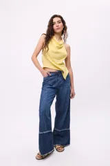 Pantalón de jean crudo, de corte recto y tiro bajo, con doble pasacinto y ajuste con lazo.