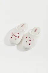 Pantuflas cerradas color blanco con corazones rojos bordados y la frase "ti amo".