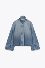 Chaqueta de denim celeste con cuello alto, manga larga con trabilla y bolsillos laterales. Presenta detalle de pliegues en la espalda y cierre frontal con botones ocultos.