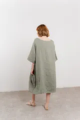 Vestido midi de lino con corte relajado y silueta fluida. Presenta escote redondo, mangas 3/4 y bolsillos laterales. Diseño minimalista y atemporal ideal para el verano.