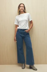 Remera blanca de cuello bote con frunces en los hombros y mangas cortas.