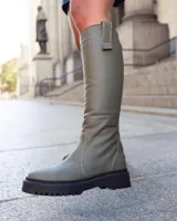 Bota de caña alta en color verde militar, con diseño moderno y suela gruesa.