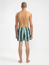 Short de baño para hombre con estampado de flores rosas sobre fondo gris, calce relajado, cintura elástica con cordón regulable, bolsillos laterales y bolsillo trasero con cierre. Incluye suspensor de malla fina hipoalergénico.