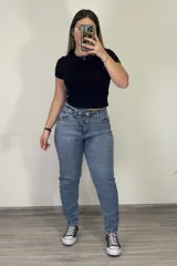 Pantalón jean mom celeste de tiro alto, corte holgado y tobillos ajustados.