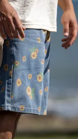 Bermuda de jean azul con estampado de girasoles, corte holgado.