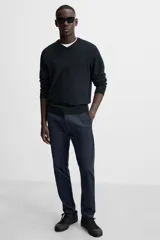 Pantalón chino azul marino, corte skinny fit, confeccionado en tejido de algodón con elasticidad. Cuenta con bolsillos frontales y traseros de vivo. Cierre frontal con cremallera y botón.