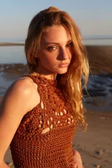 Vestido largo de crochet color marrón con diseño calado y flecos en el ruedo. Tejido a mano con hilos de lurex.