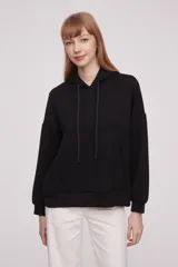 Buzo deportivo negro con capucha y diseño holgado, ideal para actividades casuales.