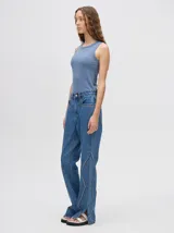 Pantalón de jean azul de tiro alto y corte oxford con apliques metálicos en bolsillos y laterales.