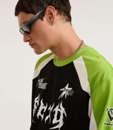 Remera de poliéster negra con mangas raglán verde lima y detalles blancos en los hombros. Presenta estampados con tipografías y gráficos en blanco en el frente.