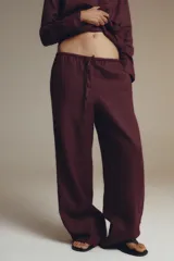 Pantalón palazzo color ladrillo confeccionado en lino 100%. Tiro medio, cintura ajustable con cordones, bolsillos laterales ocultos en costura y pierna ancha.