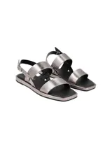 Sandalias plateadas de cuero graneado, con doble tira ancha sobre el empeine, pulsera con hebilla al tobillo y suela plana.