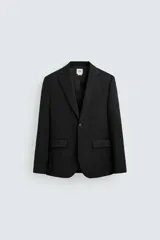 Blazer negro de lana con corte regular fit, cuello con solapas de muesca, manga larga con puños abotonados, bolsillos de vivo en pecho y de solapa en cadera, bolsillo interior, aberturas en espalda y cierre frontal con botones.