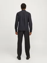 Camisa de algodón orgánico de manga larga color negro, con cuello clásico, dos bolsillos frontales con solapa y cierre con botones.