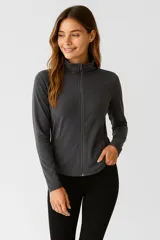 Campera gris con cierre frontal, cuello alto y bolsillos laterales.