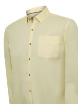 Camisa de manga larga color verde claro, confeccionada en popelina de algodón orgánico. Cuenta con cuello camisero, botones de madera, bolsillo en el pecho con logo bordado y protección UPF +20.