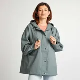 Parka verde impermeable con capucha, corte oversize, cierre frontal con cremallera y broches a presión, bolsillos laterales con solapa y puños ajustables.