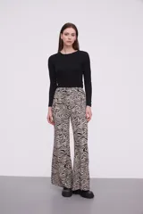 Pantalón de viscosa con estampado abstracto en tonos beige y negro, de corte palazzo y cintura con lazo ajustable.