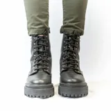Bota de cuero negra con caña media, cordones y plataforma track. Presenta apliques de tachas plateadas en el lateral exterior.