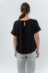 Remera blanca de viscosa liviana, con escote redondo y mangas cortas con vuelta.