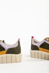 Zapatillas deportivas de cuero color beige con detalles en lila y amarillo.