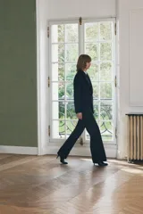 Pantalón de vestir de lana color azul marino, de tiro medio, con trabillas en la cintura, bolsillos frontales, pinzas delanteras y pierna recta.