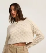 Suéter cropped de chenille color crema, con cuello redondo y mangas largas.