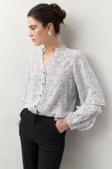 Camisa de manga larga estampada en azul y blanco, confeccionada en viscosa, con cuello mao con pequeño volado y mangas con leve volumen.