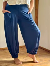 Conjunto de dos piezas color azul marino, compuesto por una remera de manga tres cuartos con escote en V y una babucha de tiro alto con bolsillos laterales y puños elastizados.