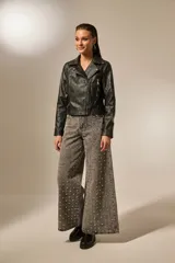 Campera de cuero sintético negra, con cuello solapa, cierre asimétrico con cremallera, bolsillos laterales con cremallera y corte entallado.