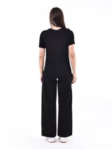 Remera negra de manga corta con cuello redondo y estampado frontal de ojos y estrellas en tonos plateados.