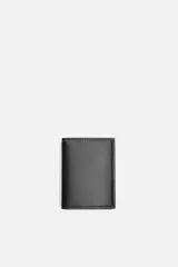Tarjetero vertical de cuero negro con pespuntes a tono. Tiene un compartimento principal con bolsillo para billetes y tres posiciones para tarjetas en cada lado.