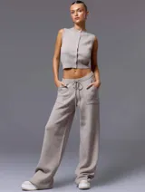 Conjunto de chaleco corto de punto con botones y pantalón de punto con bolsillos grandes y lazo en la cintura, color beige.