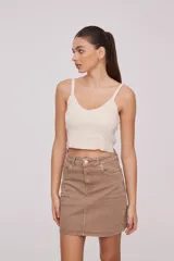 Top de bretel fino color crema, liso, al cuerpo y con escote en V.